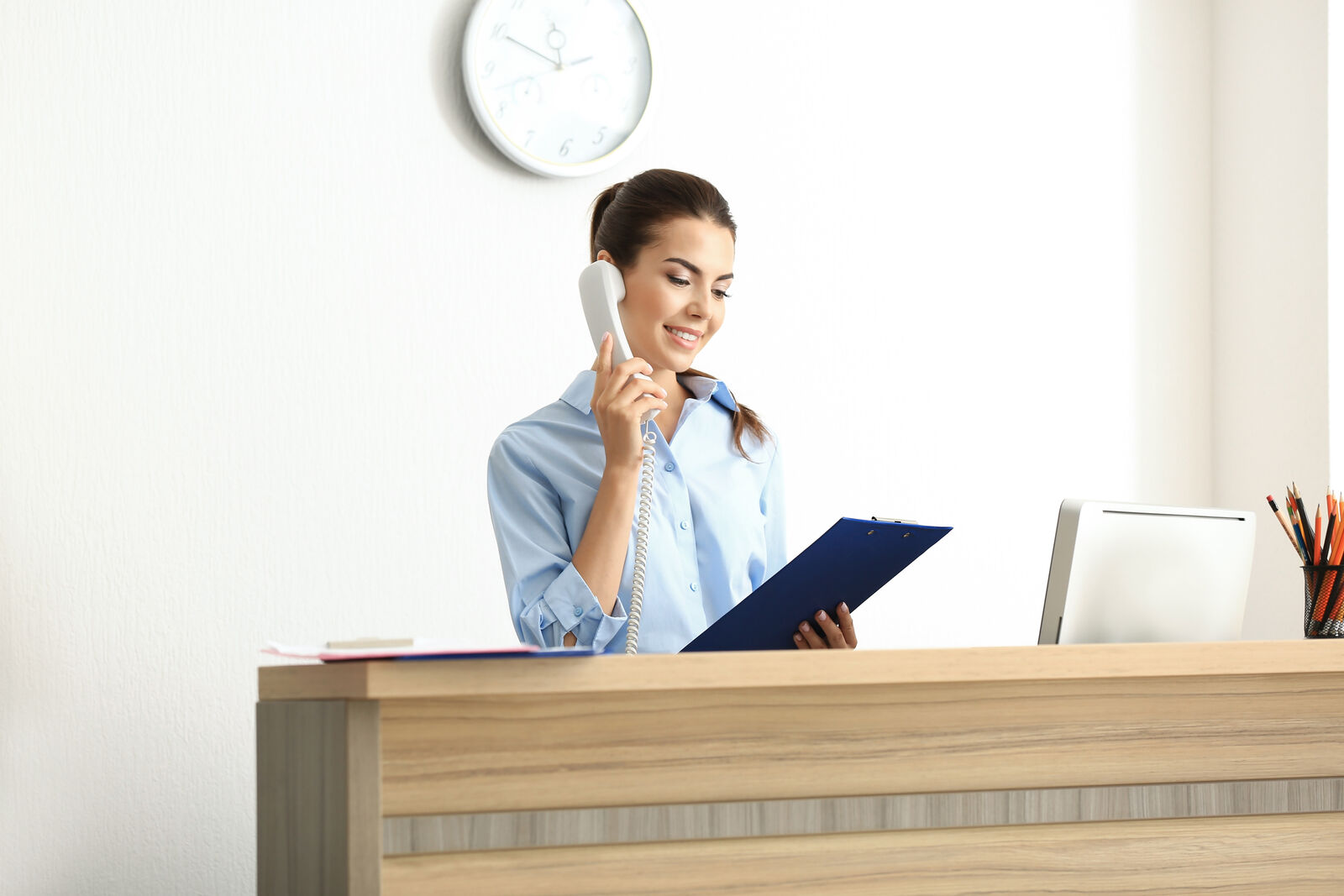 A front desk executive answering the phone