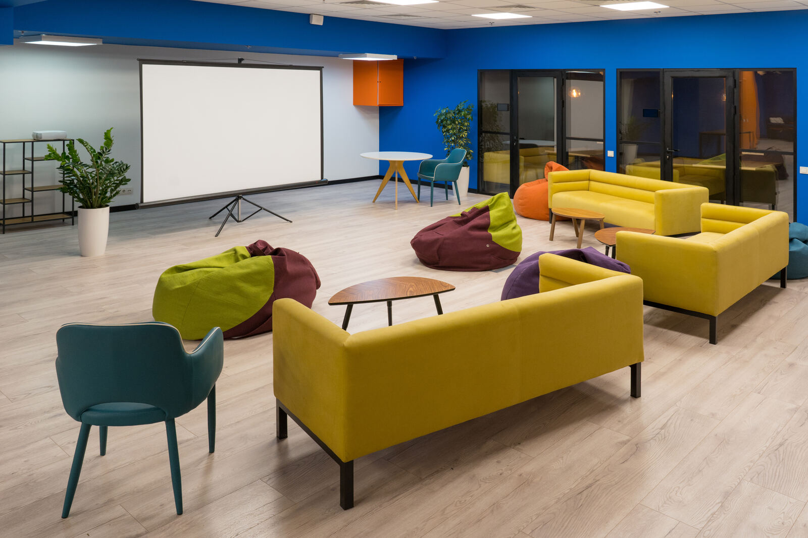 A colourful lounge with sofas and bean bags